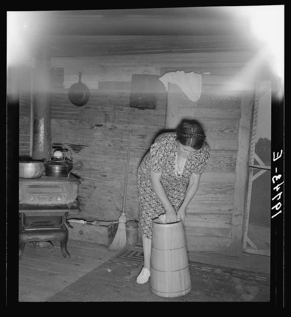 Wife of tobacco sharecropper cleaning butter churn. Person County, North Carolina. Sourced from the Library of Congress.