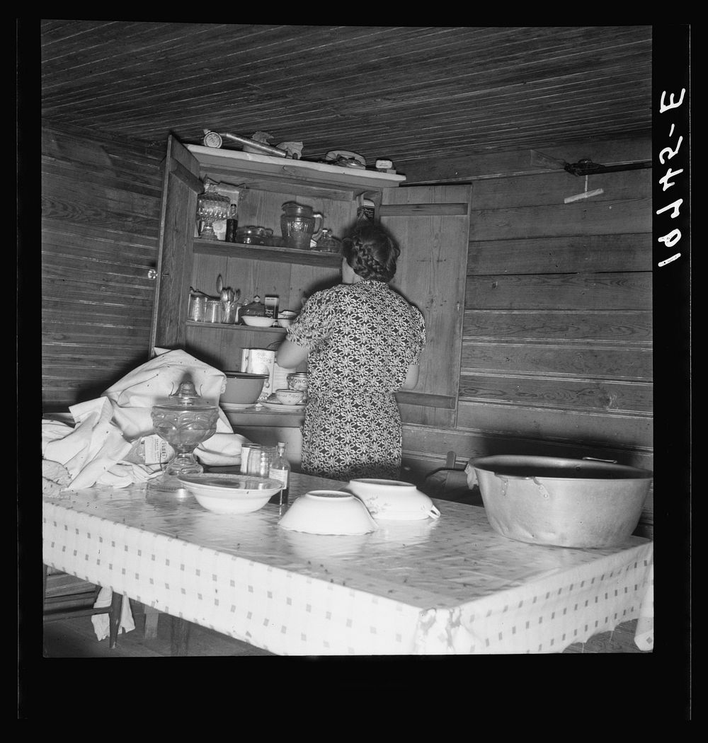 Wife of tobacco sharecropper putting breakfast dishes away. Person County, North Carolina. Sourced from the Library of…