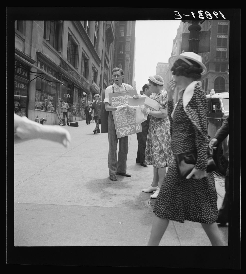 42nd Street and Madison Avenue. Street hawker selling Consumer's Bureau Guide. New York City. Sourced from the Library of…