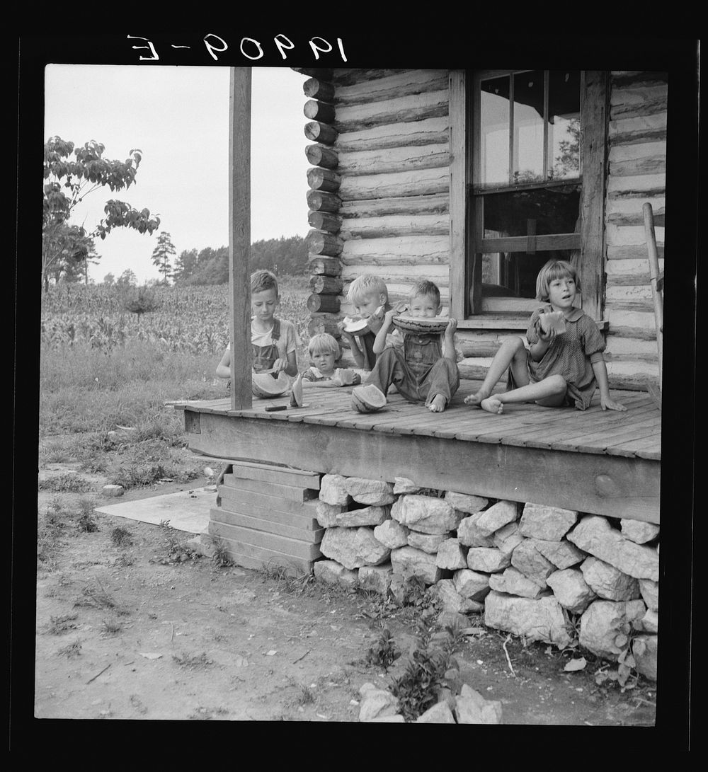 [Untitled photo, possibly related to: Millworker's children eating watermelon on porch of rented house. Six miles north of…