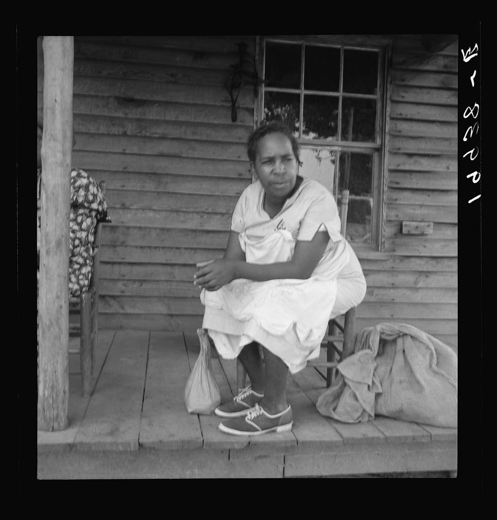 [Untitled photo, possibly related to: Mother of sharecropper family and friend coming up the road in the rain, bringing home…