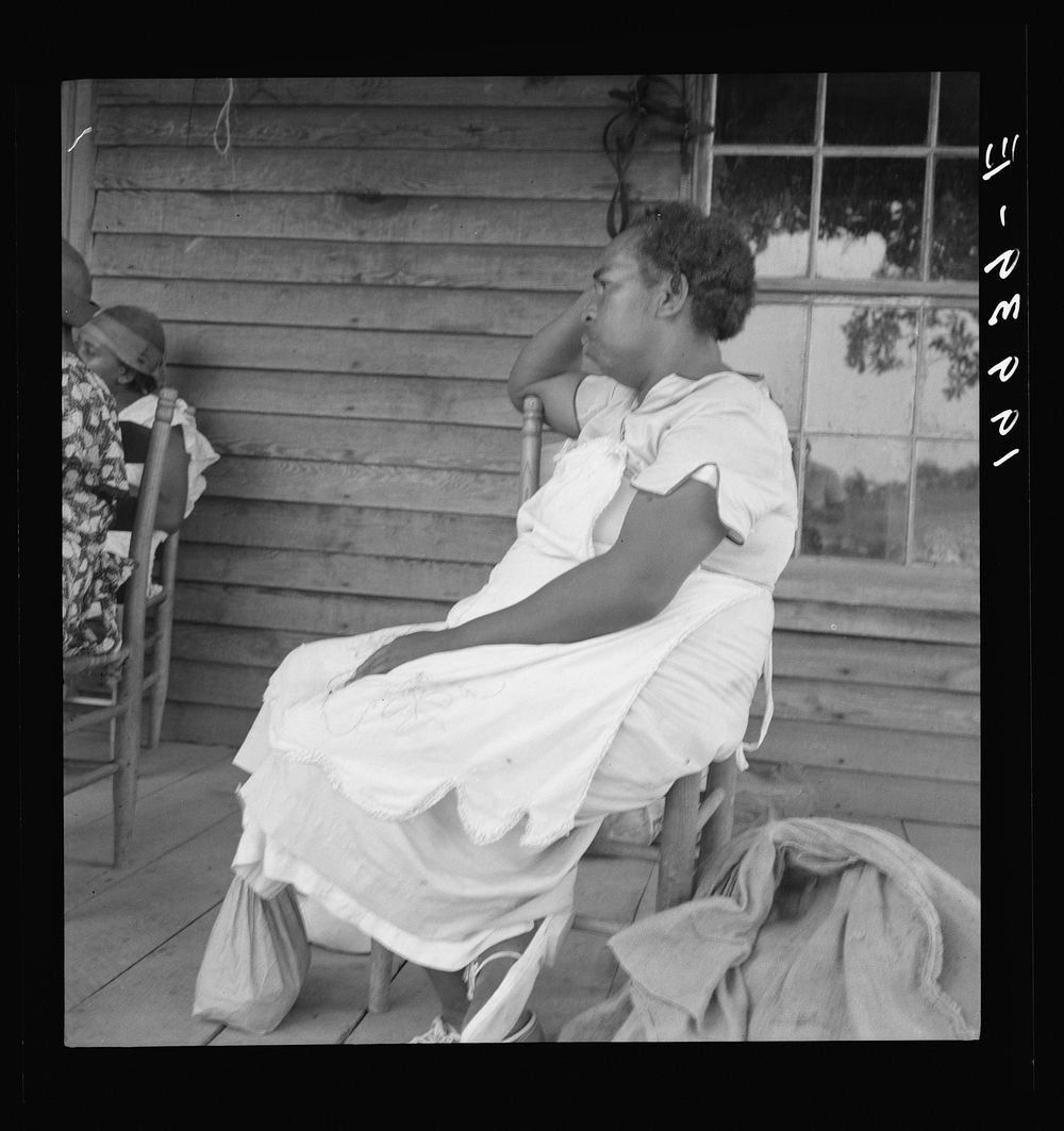 [Untitled photo, possibly related to: Mother of sharecropper family and friend coming up the road in the rain, bringing home…