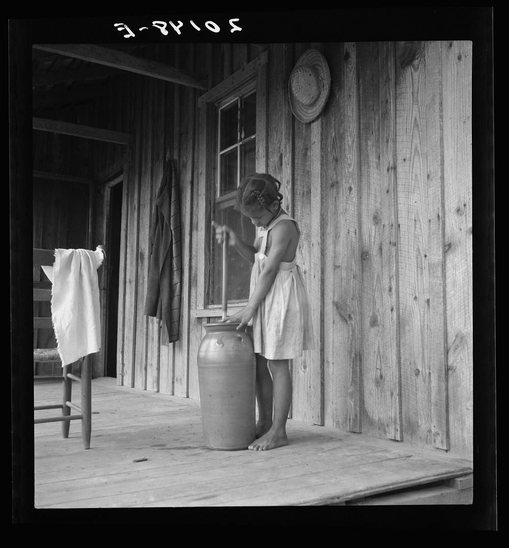 [Untitled photo, possibly related to: Pottery butter churn on porch of  tenant family. The churn is covered with a cloth to…