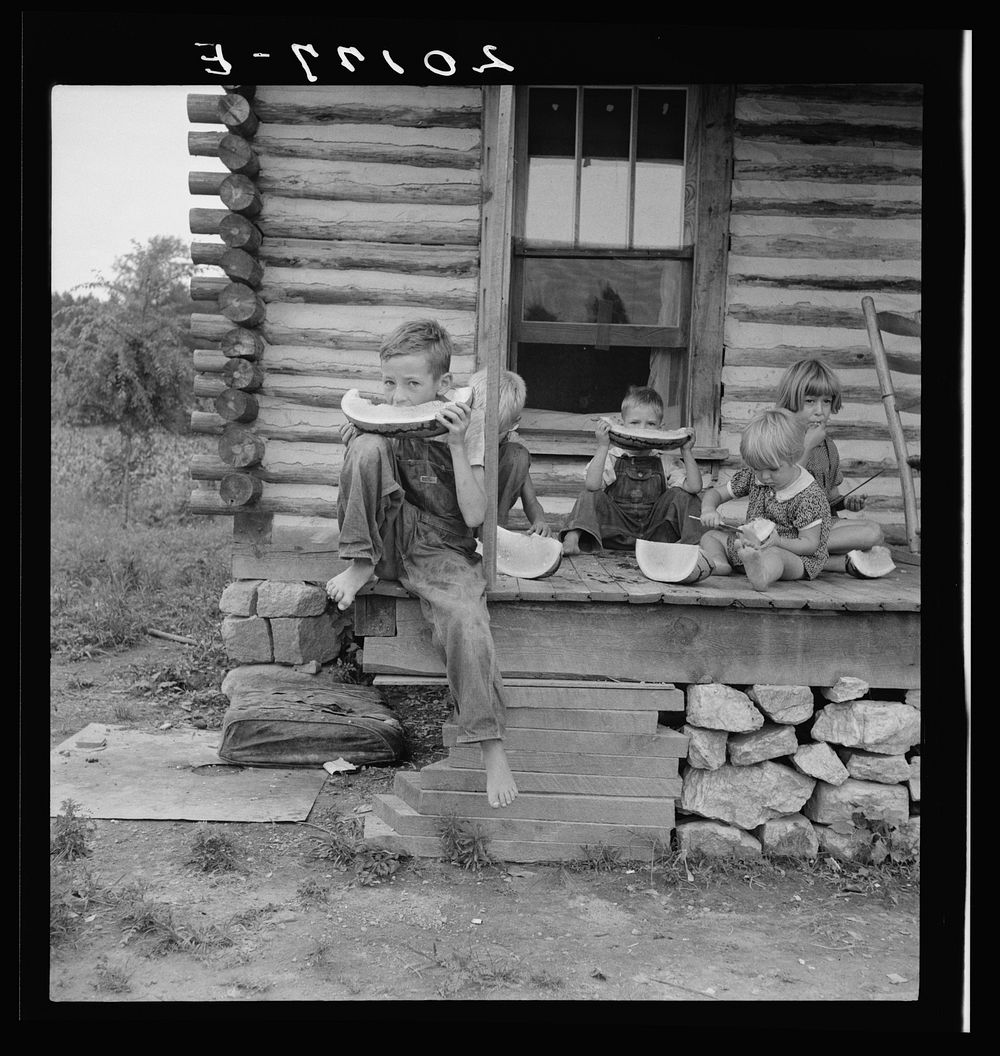 [Untitled photo, possibly related to: Millworker's children eating watermelon on porch of rented house. Six miles north of…