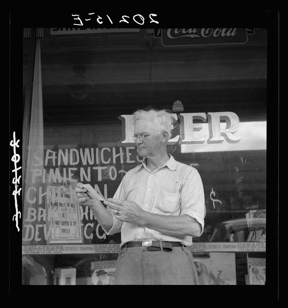 Man who was mayor of Siler City, North Carolina, twenty five years ago. Looking at old photographs of the town. Sourced from…