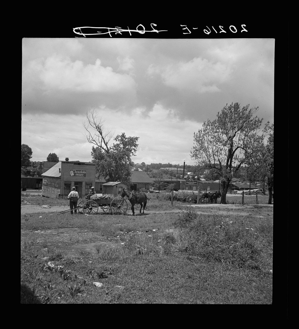 Siler City, North Carolina. Wagons pulled up in field one block away from the main street. Sourced from the Library of…