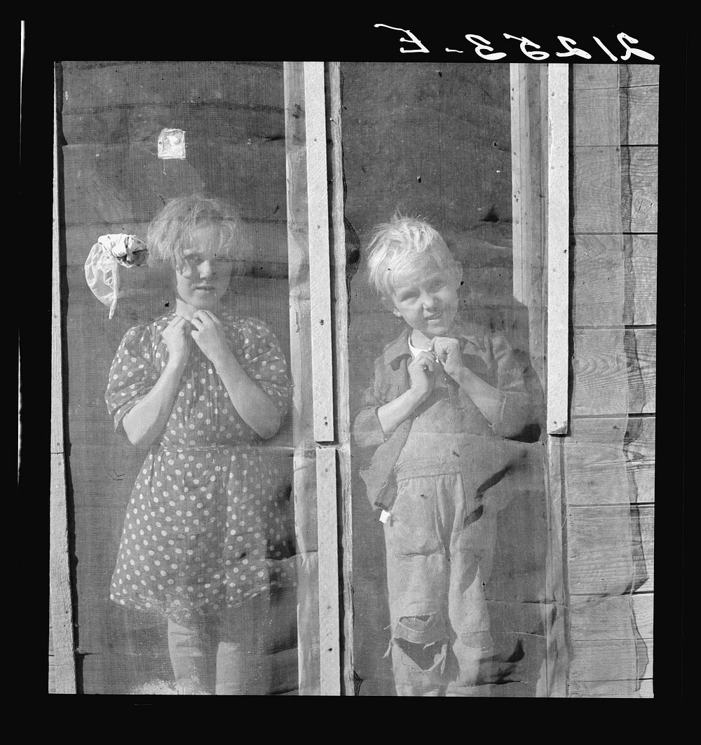 Two of the seven Browning children in doorway of their Oregon home. Dead Ox Flat, Malheur County, Oregon. General caption…