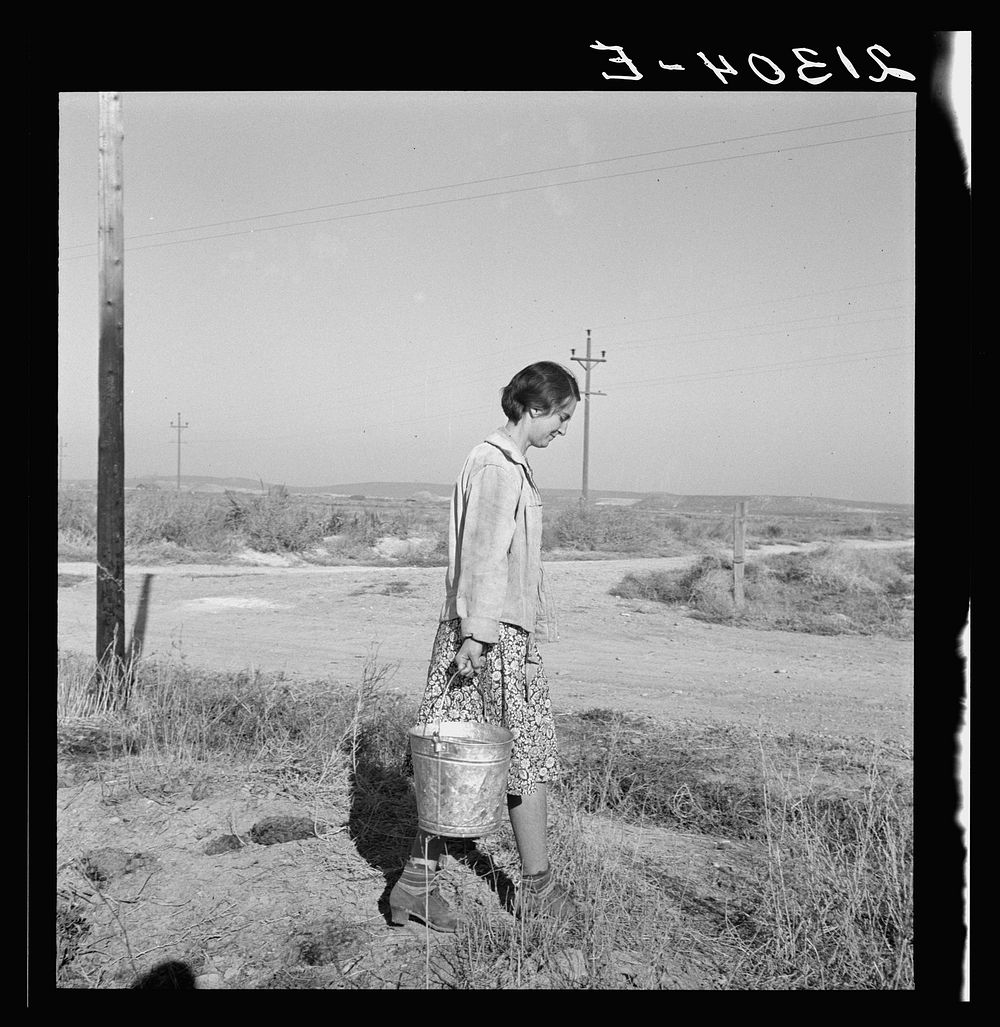 Mrs. Bartheloma hauls water from irrigation ditch. Nyssa Heights, Malheur County, Oregon. Sourced from the Library of…