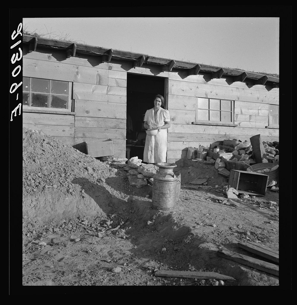 Mrs. Dougherty in doorway of basement house. Warm Springs, Malheur County, Oregon. Sourced from the Library of Congress.