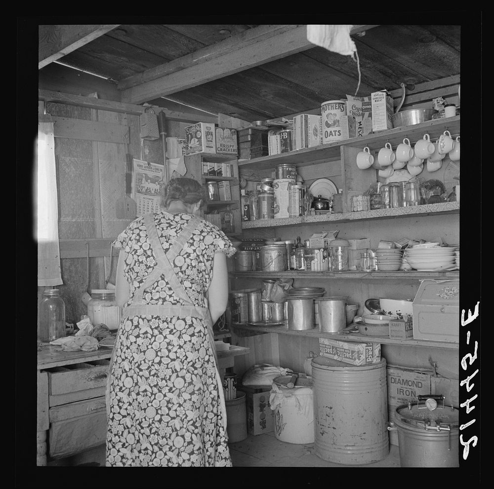 Woman getting lunch in kitchen of home. Homedale district, Malheur County, Oregon. Sourced from the Library of Congress.