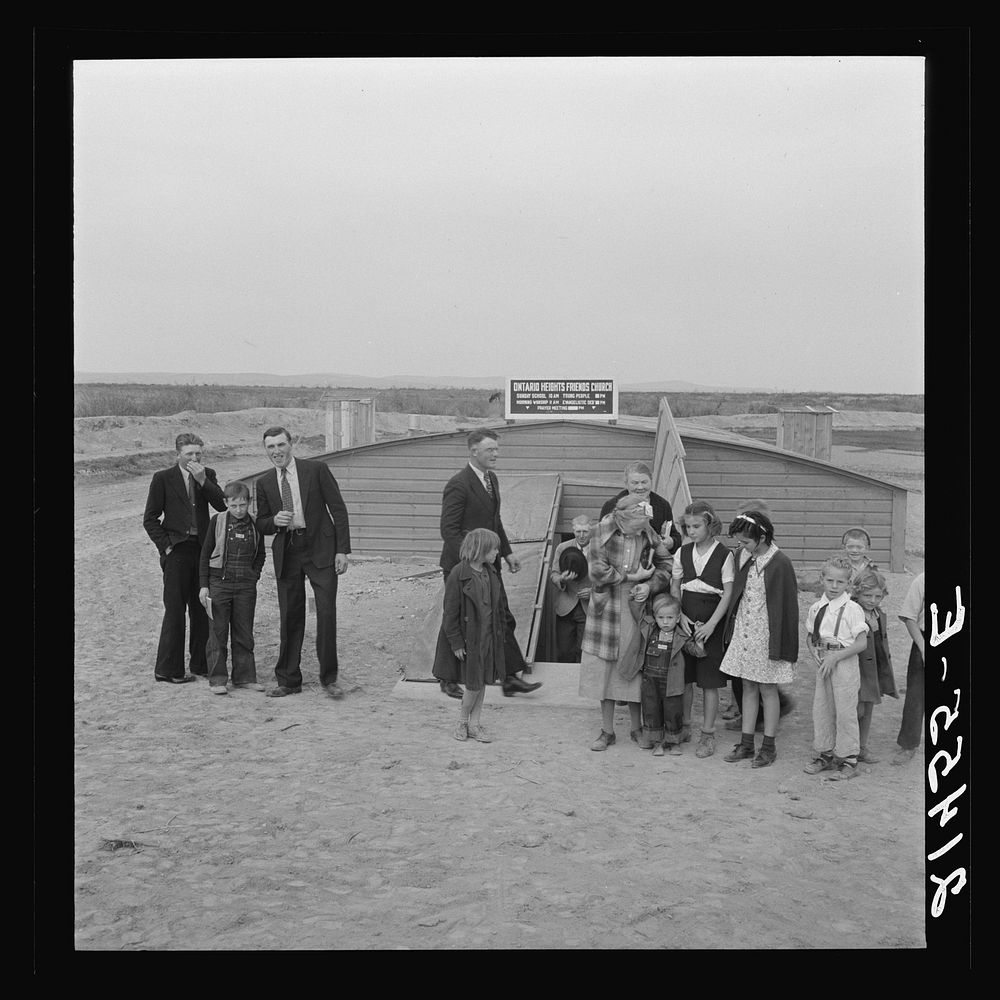[Untitled photo, possibly related to: Congregation leaving after services. Preacher in doorway. Dead Ox Flat, Malheur…
