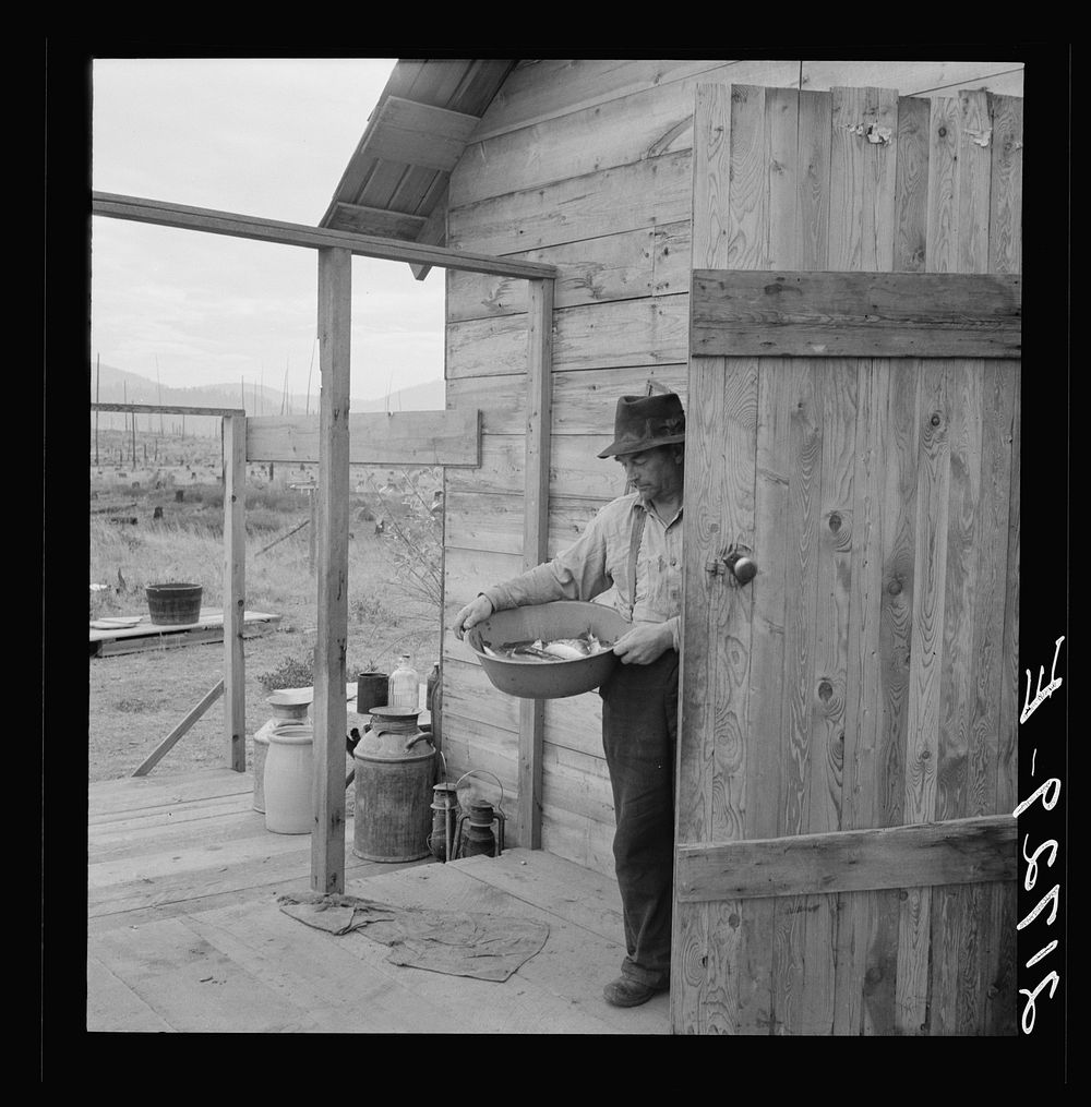 New settler shows fish he caught this morning. He "likes it fine here." Priest River Valley, Bonner County, Idaho. See…