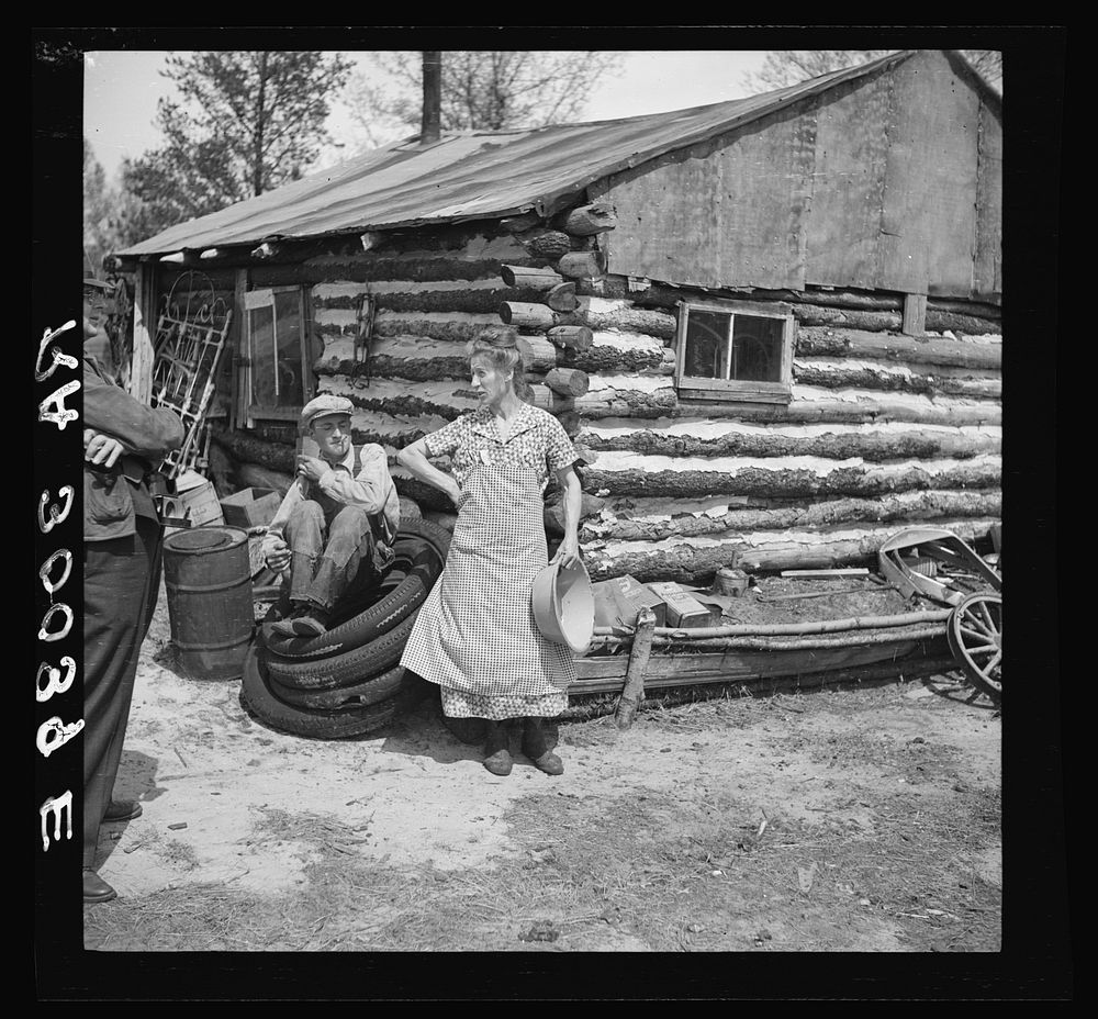 Mrs. Hale and her oldest son in front of their home near Black River Falls, Wisconsin. This farm house was built with a…