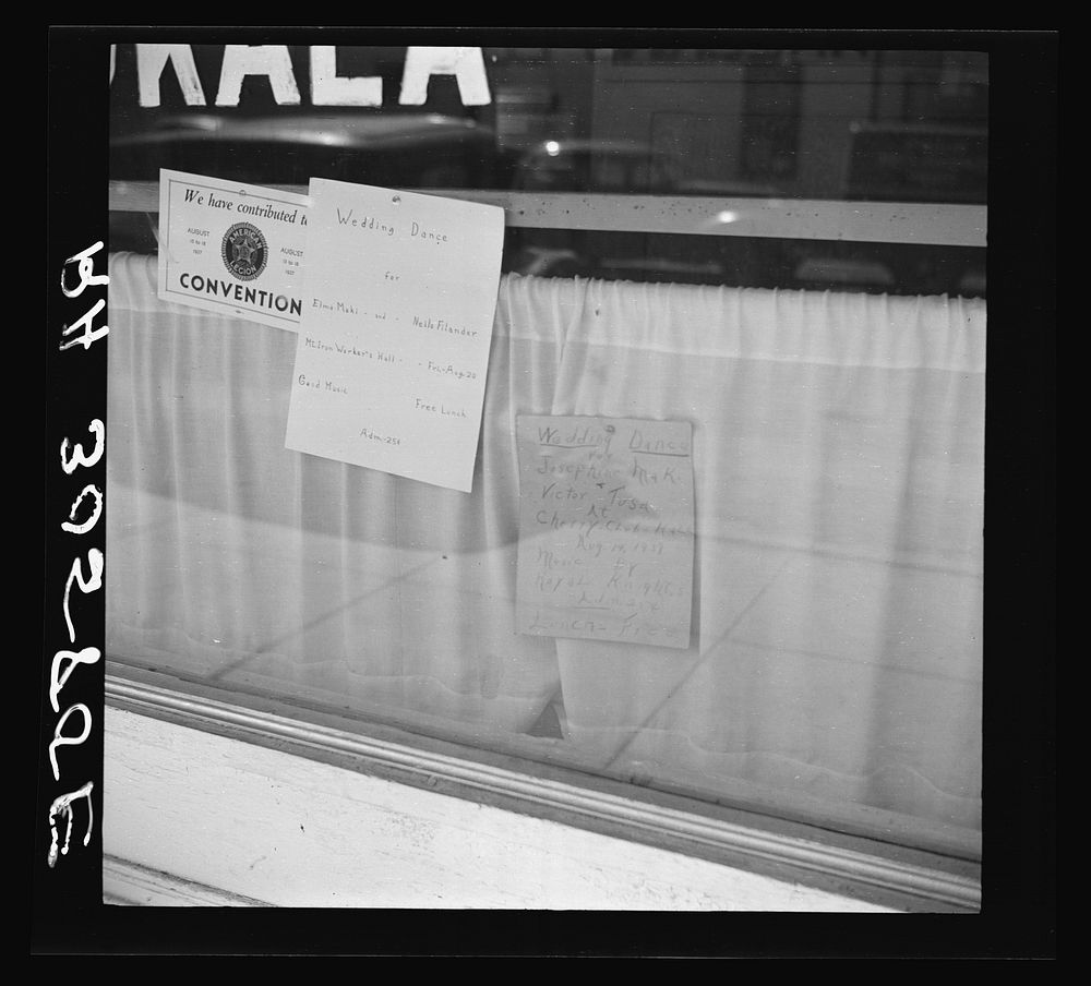 Signs in store window. Virginia, Minnesota by Russell Lee