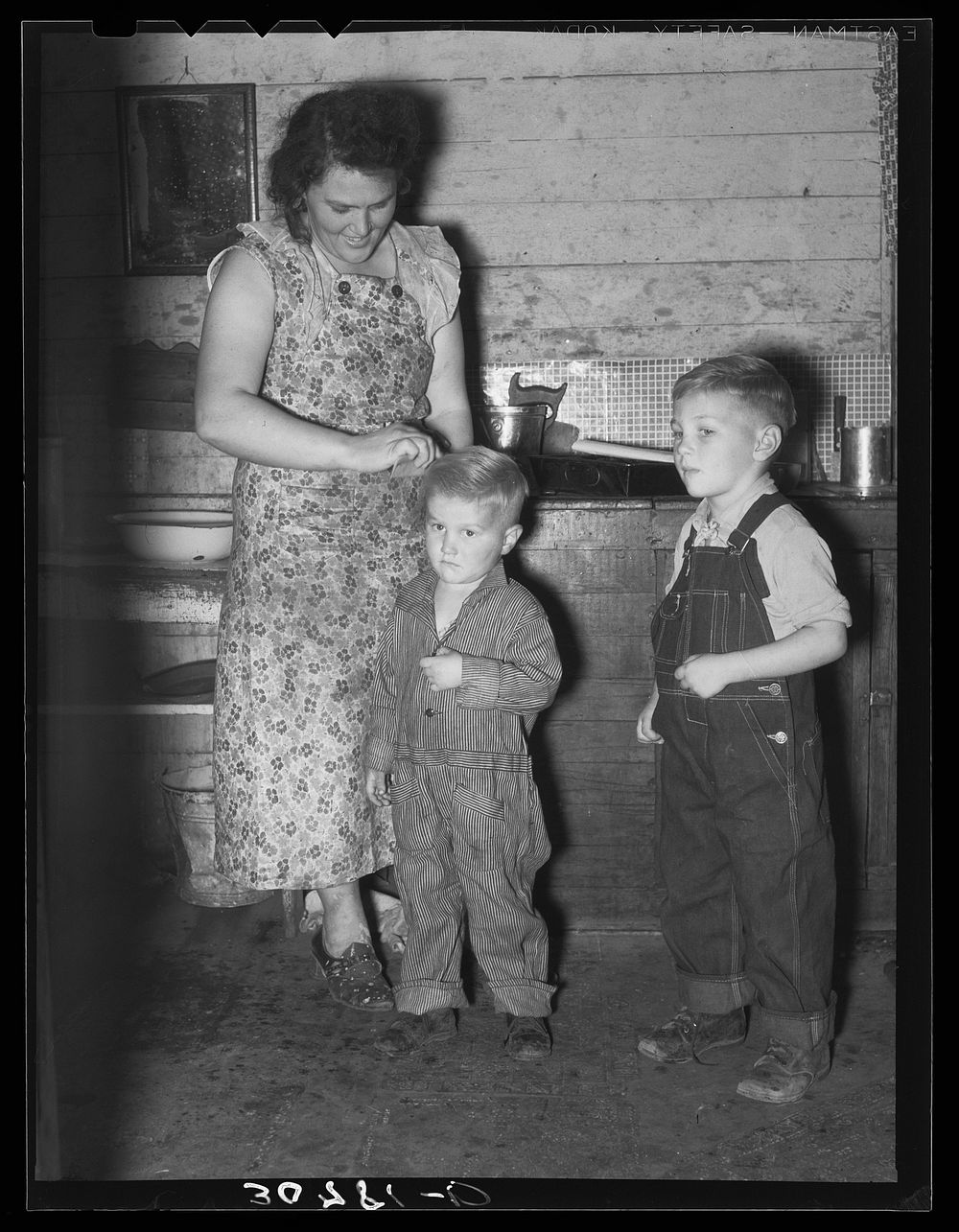 Mother dressing up her children. Farm home, Williams County, North Dakota by Russell Lee