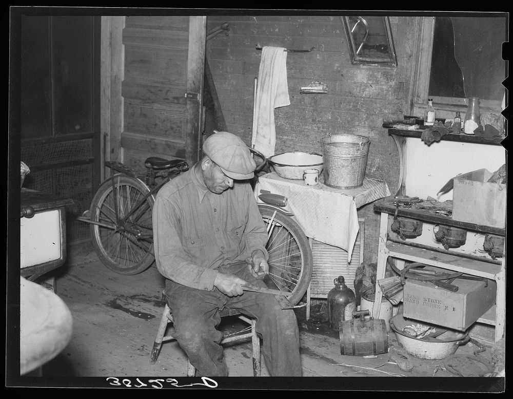 Beet worker sharpening topping knife. East Grand Forks, Minnesota by Russell Lee