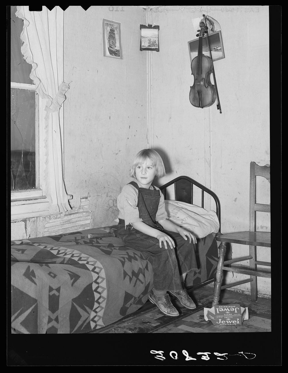 Child of James Strunk in corner of living room. Near Wheelock, North Dakota by Russell Lee