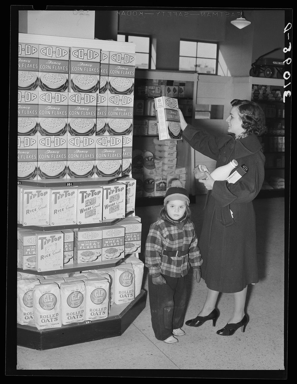 Resident at Greenbelt with child in the Greenbelt cooperative grocery store. Maryland by Russell Lee