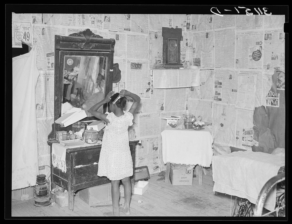 Southeast Missouri Farms. Sharecropper's child combing hair in bedroom of shack home near La Forge project, Missouri by…