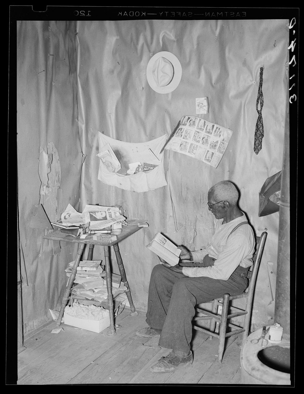 New Madrid County, Missouri. Old  sharecropper reading the Bible in his living room by Russell Lee
