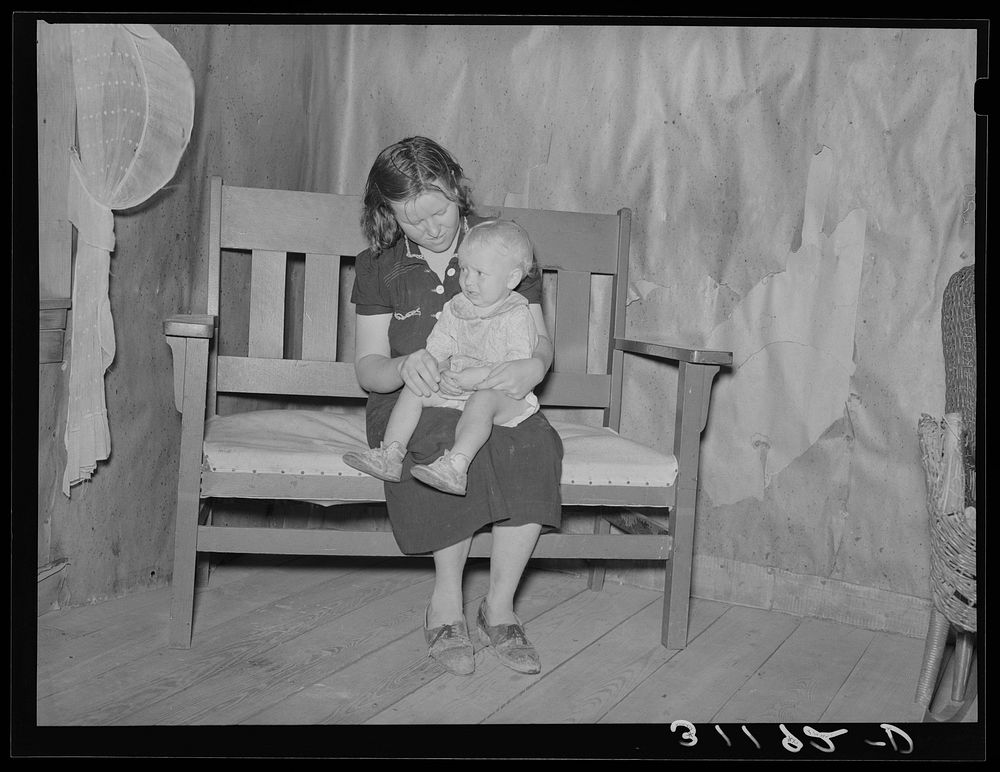Southeast Missouri Farms. Mother and child sitting on settee in sharecropper cabin by Russell Lee