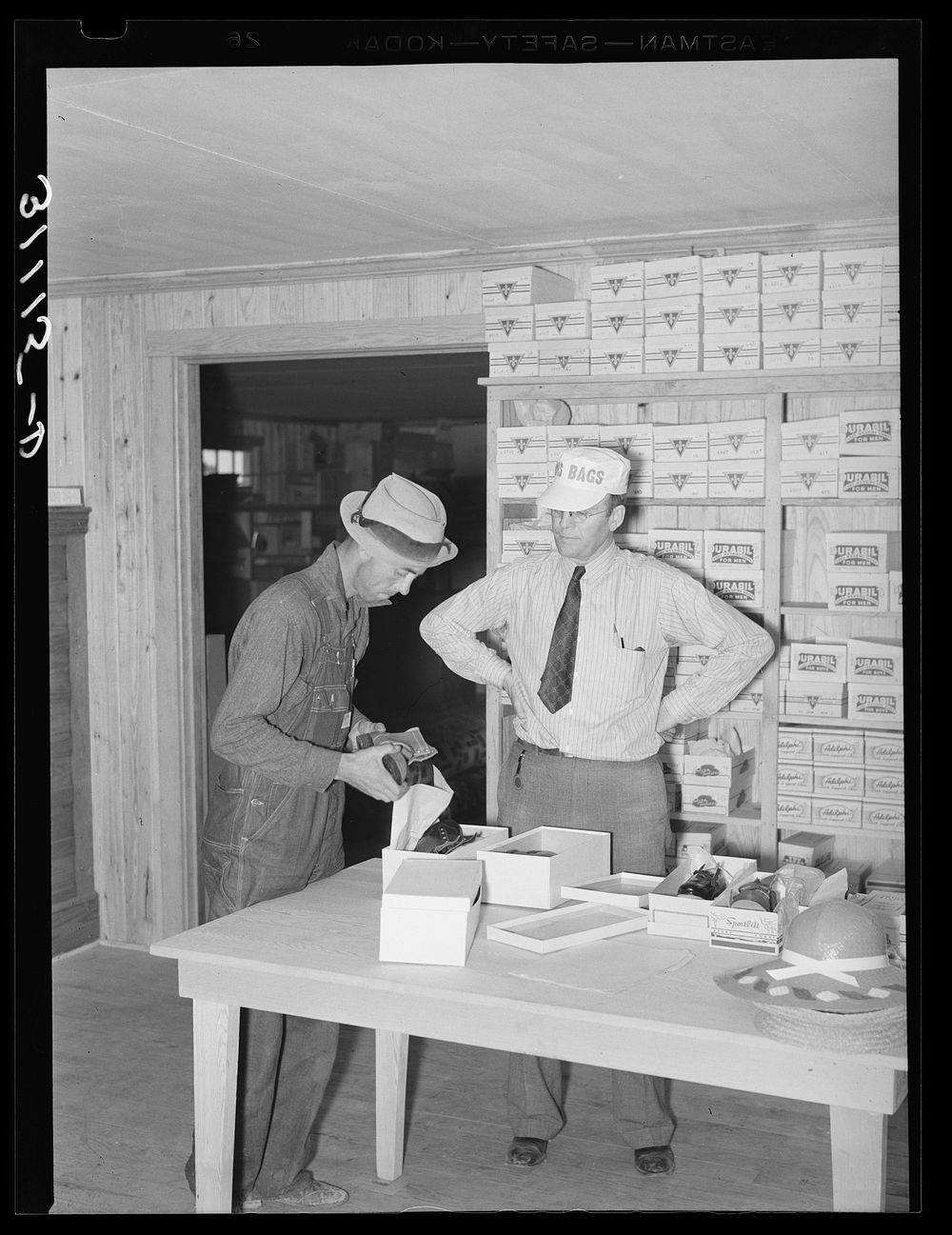 Southeast Missouri Farms. Buying pair of shoes at cooperative store. La Forge project, Missouri by Russell Lee