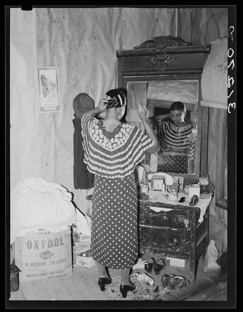New Madrid County, Missouri. Wife of sharecropper dressing her hair by Russell Lee