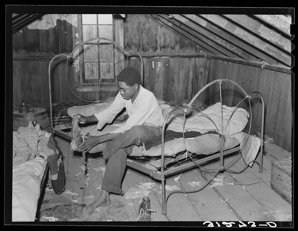 [Untitled photo, possibly related to: Boy on bed in attic of sharecropper shack. New Madrid County, Missouri] by Russell Lee