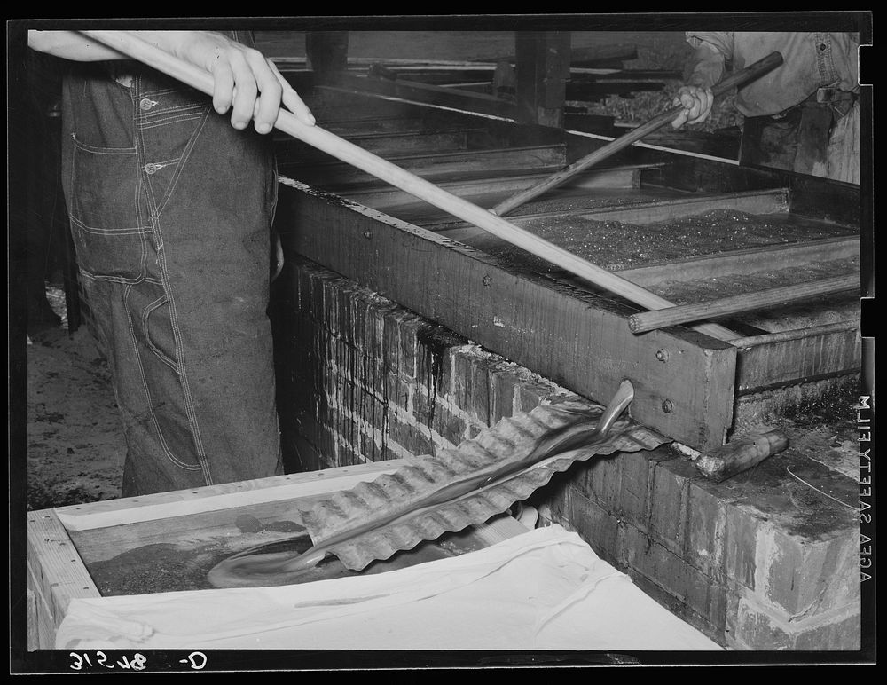 Finished sorghum pouring from vats. Lake Dick Project, Arkansas by Russell Lee