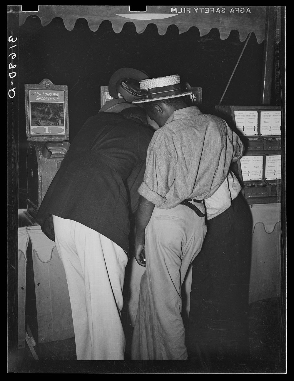 [Untitled photo, possibly related to: Boys looking at penny movies at South Louisiana State Fair. Donaldsonville, Louisiana]…