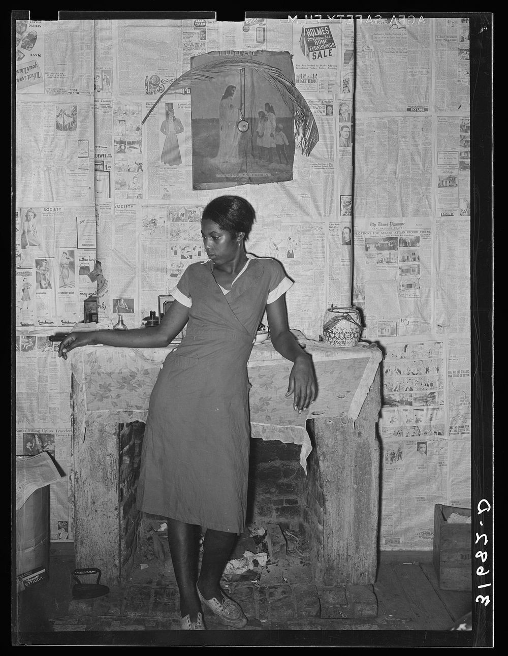 Girl in front of fireplace in home along levee near Norco, Louisiana by Russell Lee