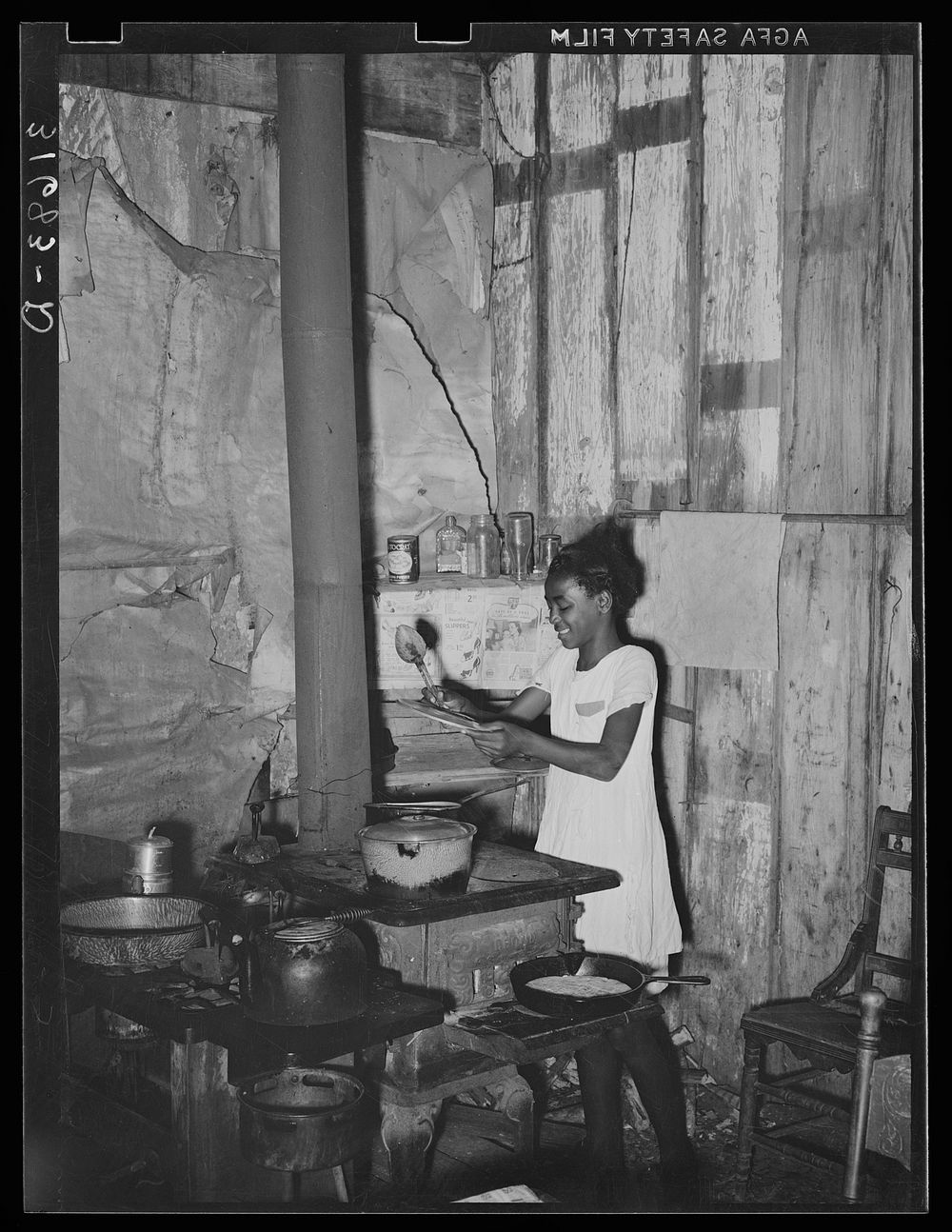  girl attending to food and stove in corner of kitchen, once a room in the old Trepagnier plantation house. Norco, Louisiana…