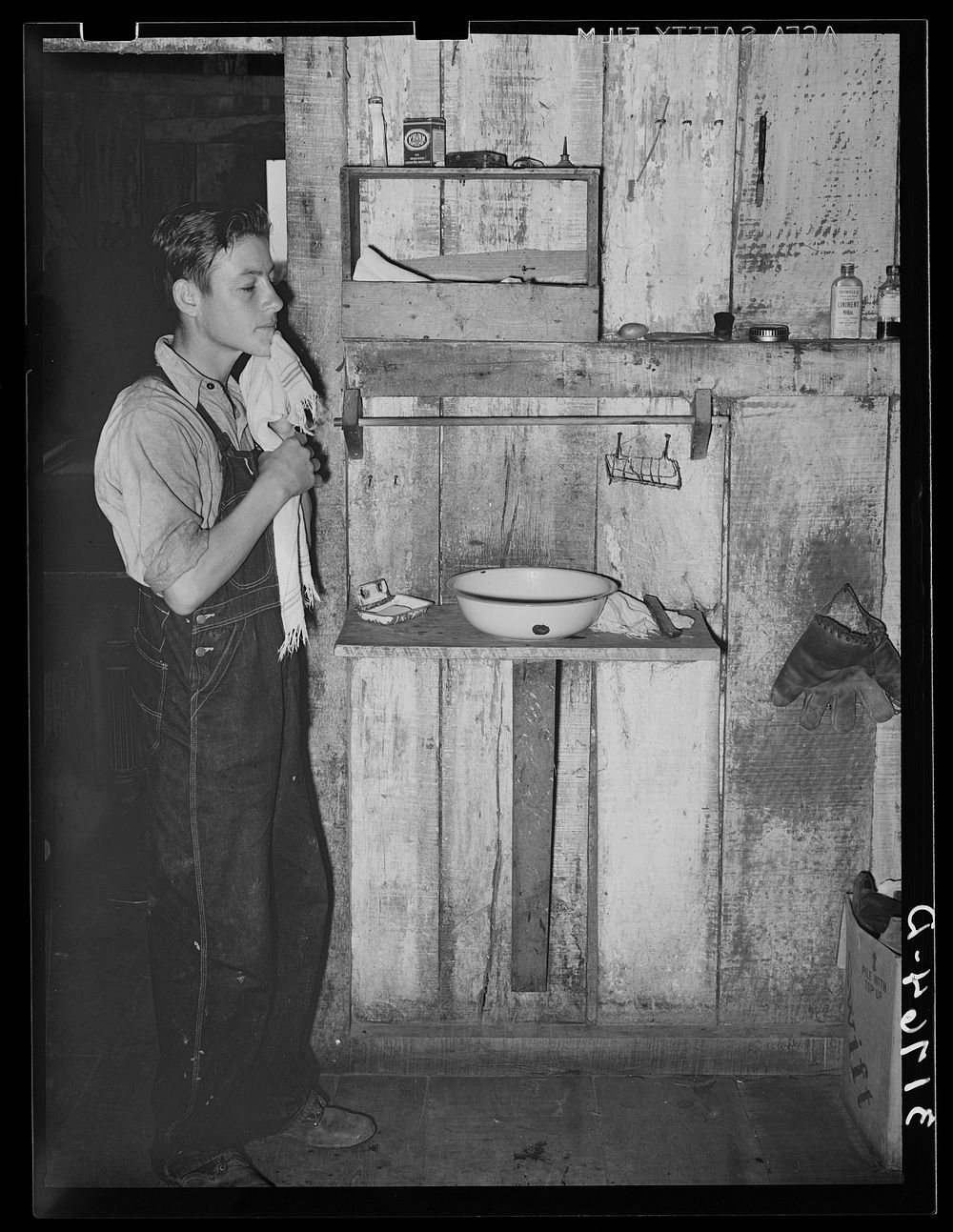 Son of M. LaBlanc washing his face in farm home. Morganza, Louisiana. M. LaBlanc is a tenant purchase client by Russell Lee