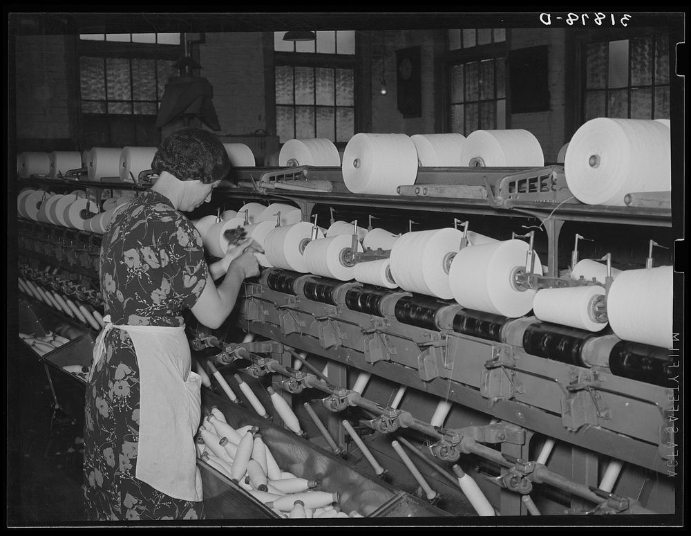 Worker winding cotton thread onto large spools. Laurel cotton mills, Laurel, Mississippi by Russell Lee