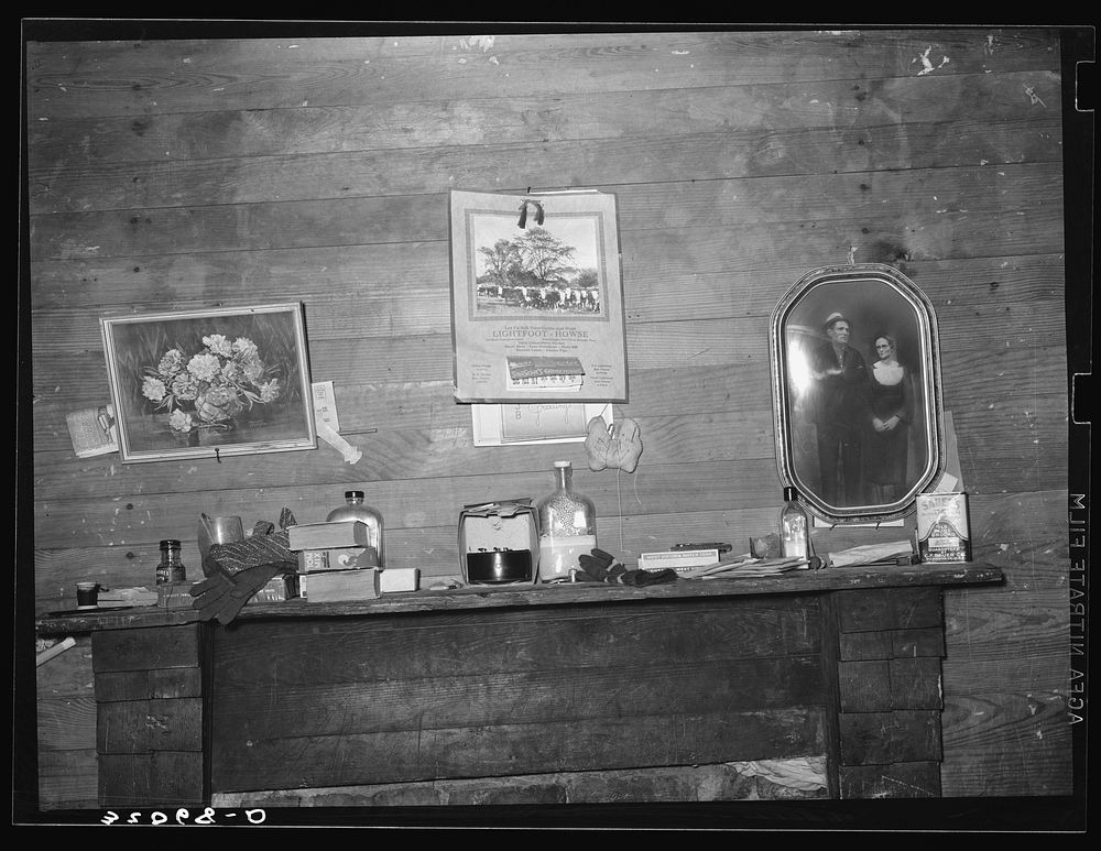 Decorations above mantelpiece in farm home near Merigold, Mississippi. Background photo for Sunflower Plantation by Russell…