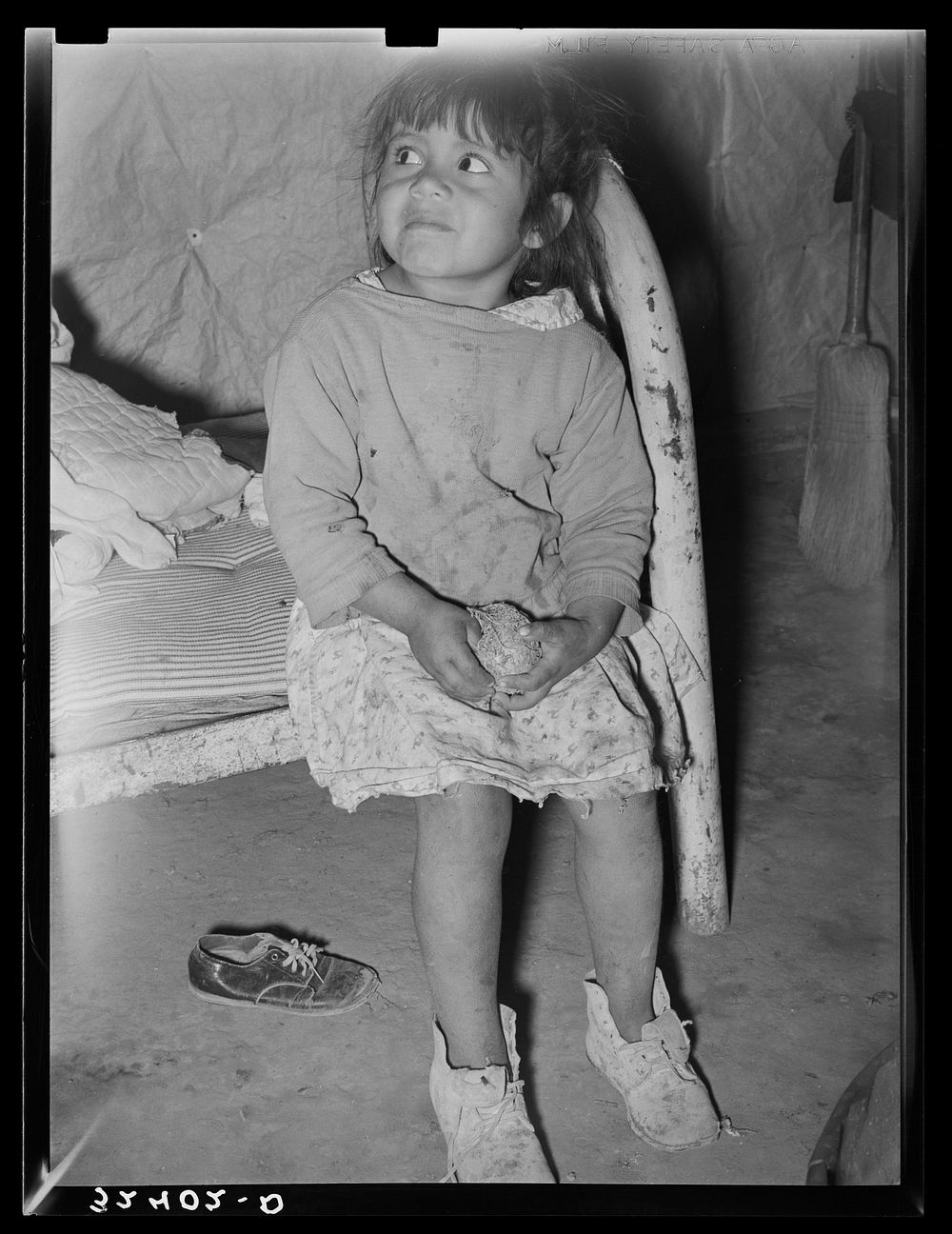 Mexican child in bed. Note dirt floor. Crystal City, Texas by Russell Lee