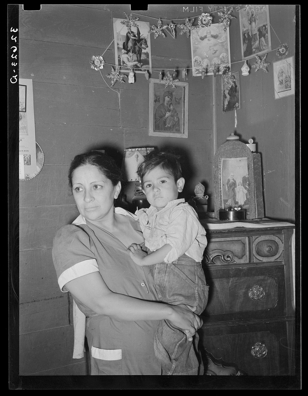 Mexican mother and child in front of shrine in corner of room. San Antonio, Texas by Russell Lee
