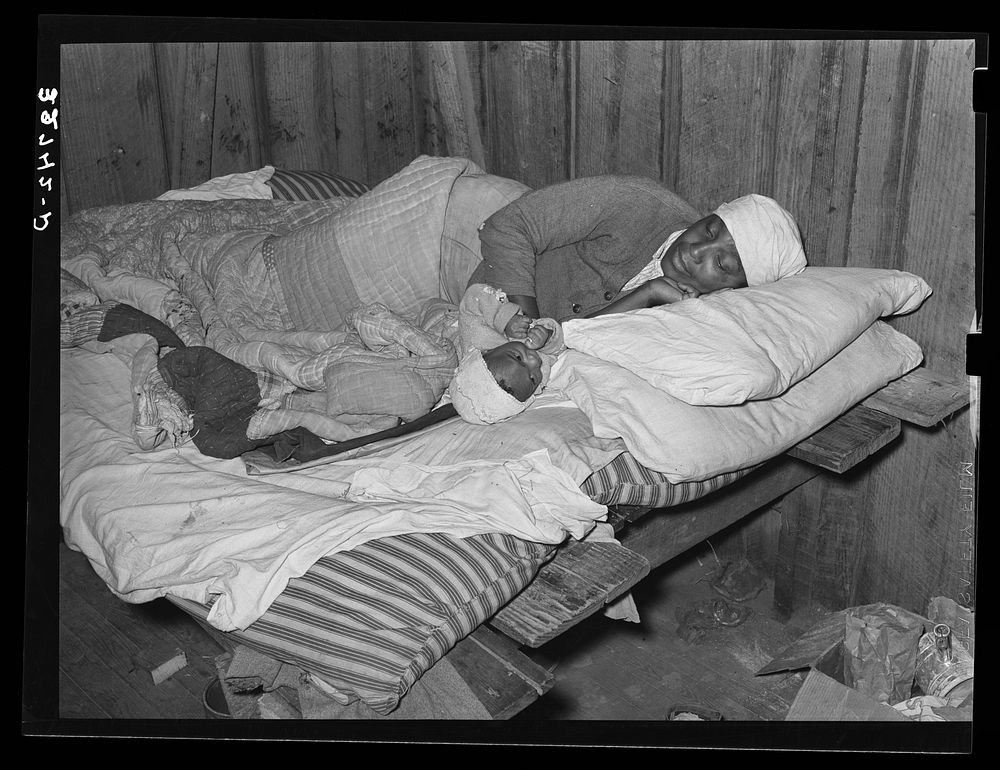  mother and baby in bed in the house furnished them while working in the strawberry fields near Independence, Louisiana by…
