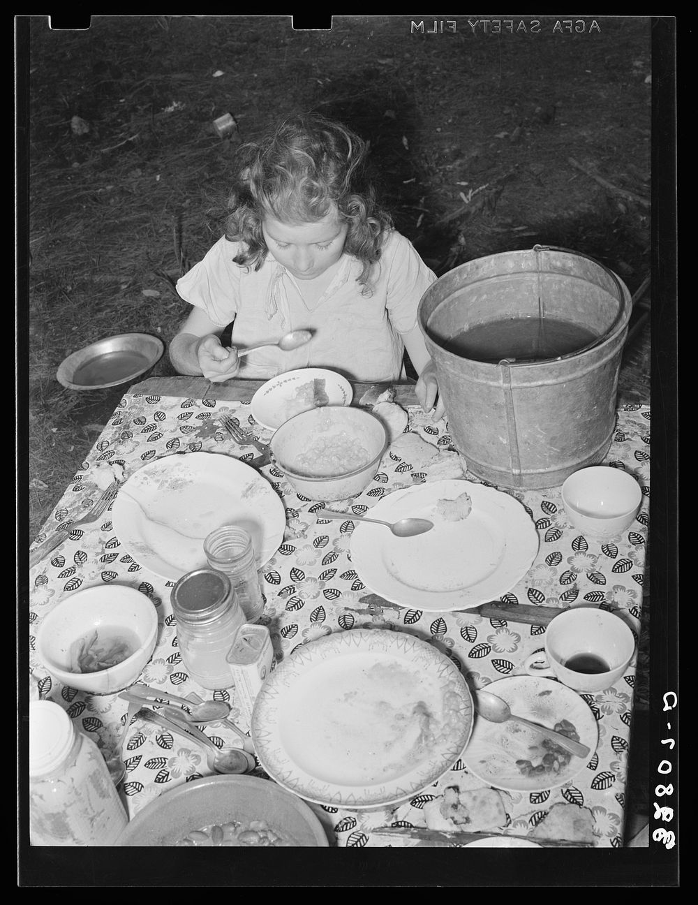 Daughter of white migrant berry picker eating dinner. Hammond, Louisiana by Russell Lee