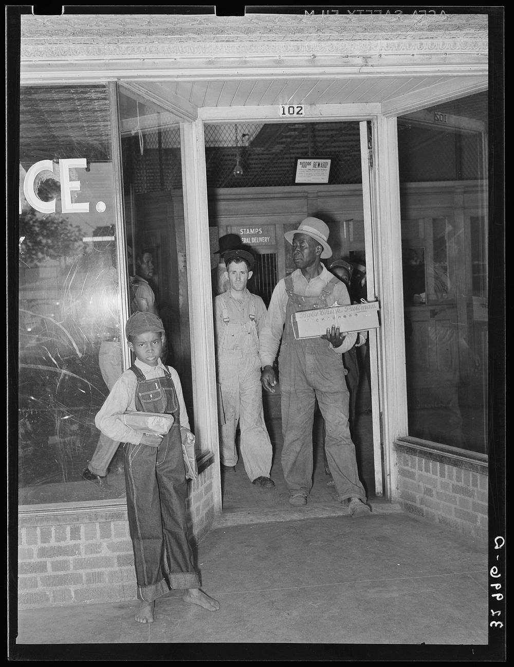 Post office.  coming out of door with carton of baby chicks. San Augustine, Texas by Russell Lee