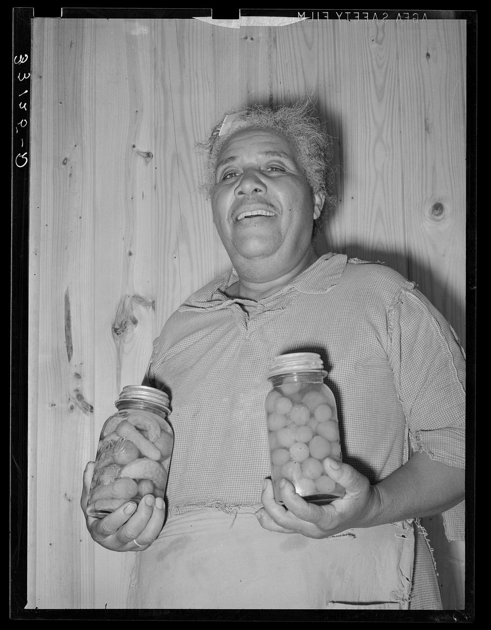 Wife of FSA (Farm Security Administration) client with home-canned vegetables. Sabine Farms, Marshall, Texas by Russell Lee