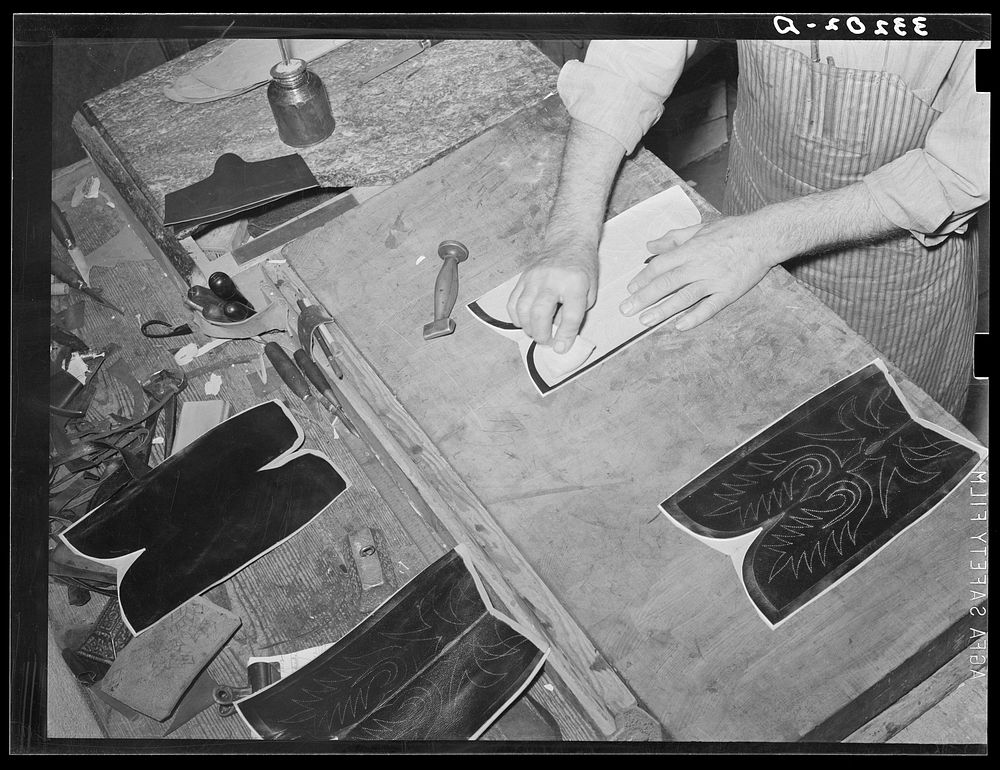 Transferring pattern for stitching on the uppers of the boots. Bootmaking shop, Alpine, Texas by Russell Lee