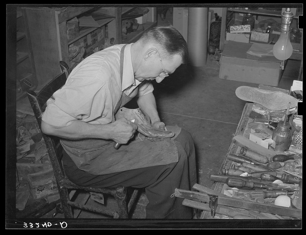Trimming inner sole to conform to last. Cowboy bootmaking shop, Alpine, Texas by Russell Lee