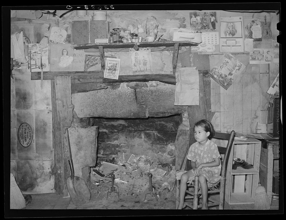 Indian child in front of mantelpiece in his home near Sallisaw, Oklahoma by Russell Lee