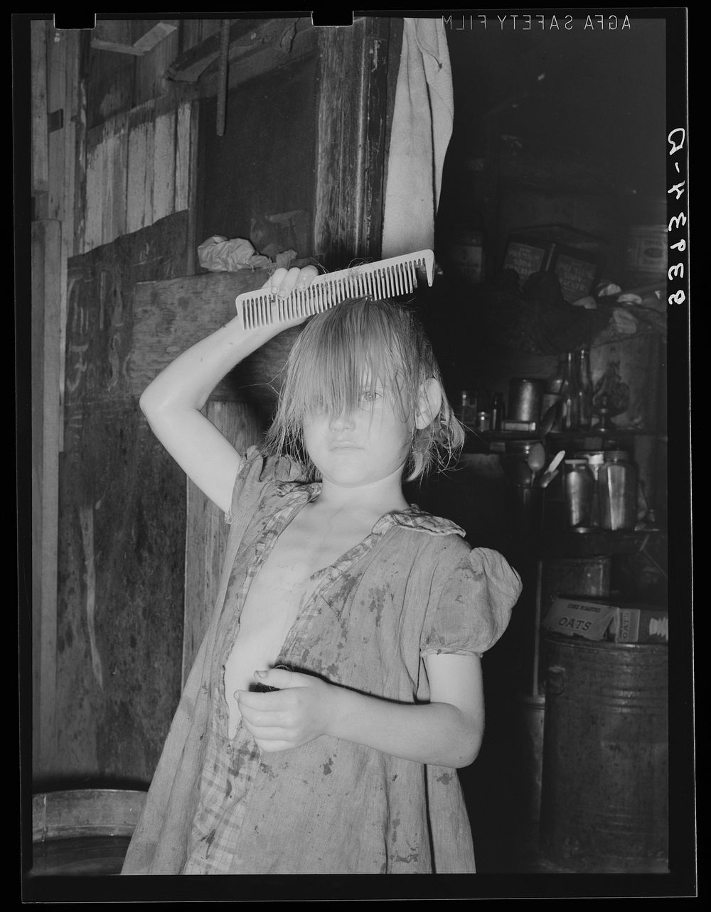Little girl combing hair. She lives in camp near Mays Avenue. Oklahoma City, Oklahoma. See general caption no. 21 by Russell…