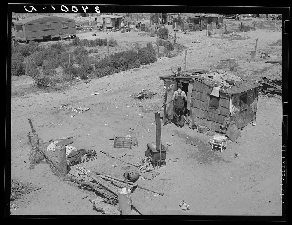 Shack home and yard. Mays Avenue camp, Oklahoma City, Oklahoma. Notice crude fence made of old water boilers and discarded…