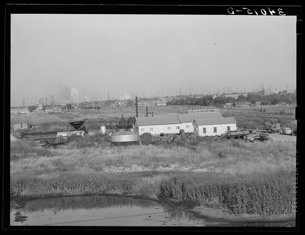Independent refinery. Business section of Oklahoma City, Oklahoma in background by Russell Lee