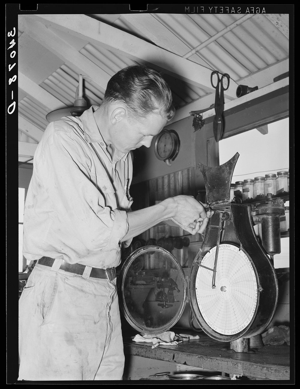 Recording thermometer repairman at oil refinery. Seminole, Oklahoma by Russell Lee