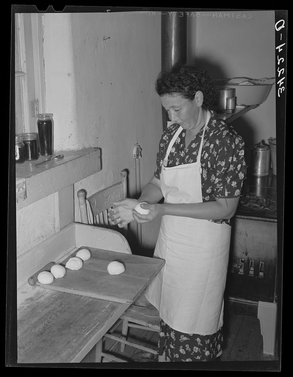 Shaping dough into balls before rolling out tortillas. Spanish-American home near Taos, New Mexico, Taos County by Russell…