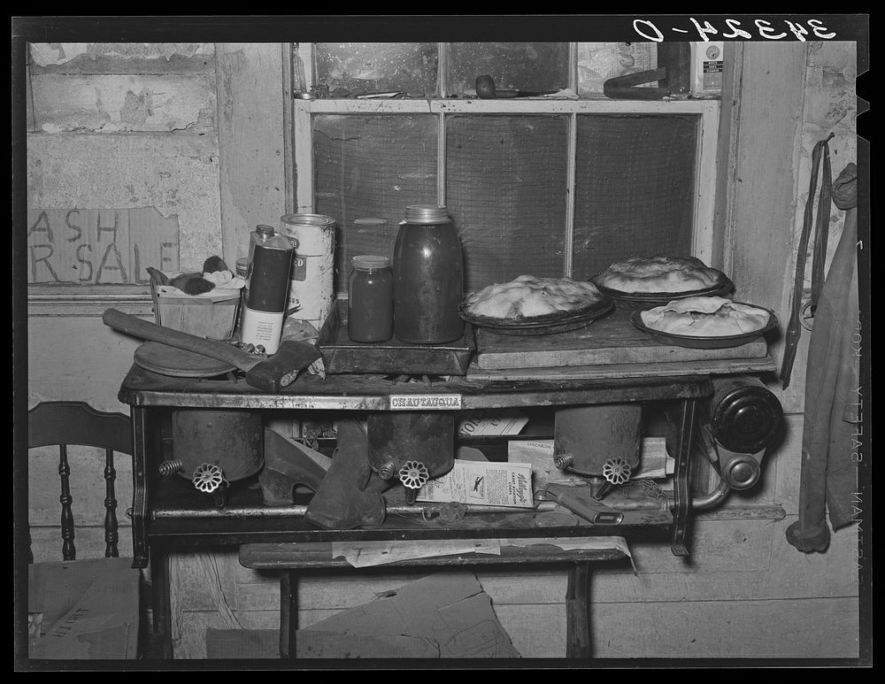Pies, canned goods and household articles on stove in farm home. Bradford, Vermont, Orange County by Russell Lee